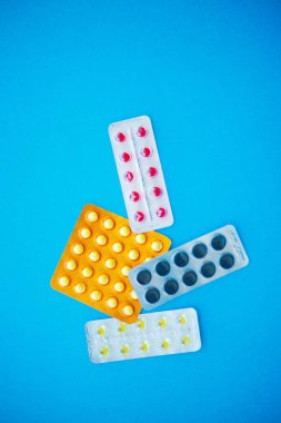 Tıbbi ilaçlar. Renkli hap ve kapsül mavi zemin üzerine. Eczane tema, kapsül hap ilaç antibiyotik paketleri ile.