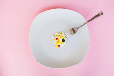 Tıbbi kavramı. Renkli hap ve kapsül çatal ile plaka üzerinde. Eczane tema, kapsül hap ilaç antibiyotik paketleri ile.