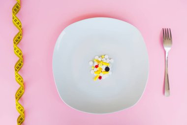 Tıbbi kavramı. Renkli hap ve kapsül çatal ile plaka üzerinde. Eczane tema, kapsül hap ilaç antibiyotik paketleri ile.