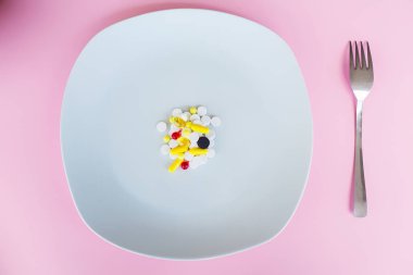 Tıbbi kavramı. Renkli hap ve kapsül çatal ile plaka üzerinde. Eczane tema, kapsül hap ilaç antibiyotik paketleri ile.