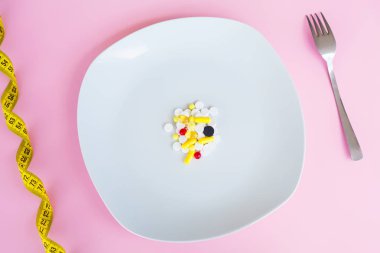 Tıbbi kavramı. Renkli hap ve kapsül çatal ile plaka üzerinde. Eczane tema, kapsül hap ilaç antibiyotik paketleri ile.