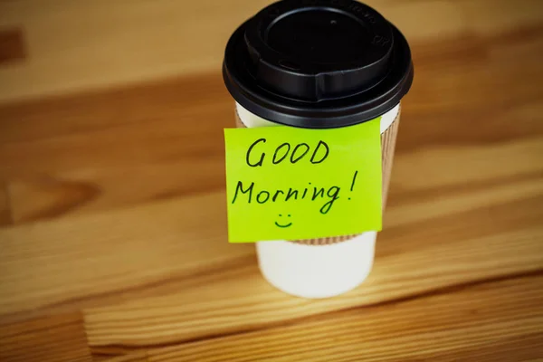 Good Morning. Coffee Time. Coffee to go and beans on a wooden background.