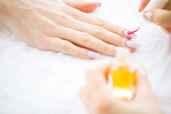 SPA manicure. Woman in a nail salon receiving a manicure by a beautician.