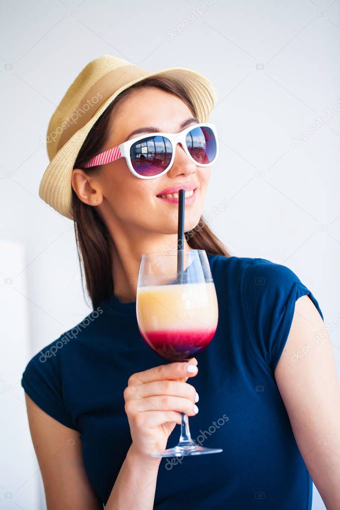 Vacation. Woman Who is Preparing for Rest. Young Beautiful Girl Sits on the Bed and Holds in the Hands Cocktail. Portrait of a Smiling Woman. Happy Girl Goes On Vacation.