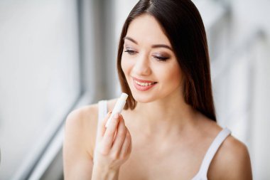 Makyaj. Güzel genç kadın ruj uygulama.