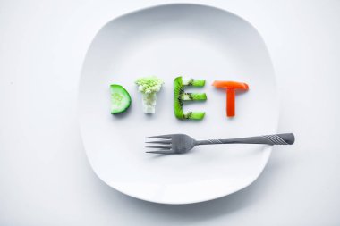 Beslenme veya kilo kontrolü kavramı. Santimetre teyp ve metin eklemek için bir yer ile beyaz bir arka plan üzerinde çatalı. Sağlık, kilo kaybı, diyet, doğru beslenme kavramı.