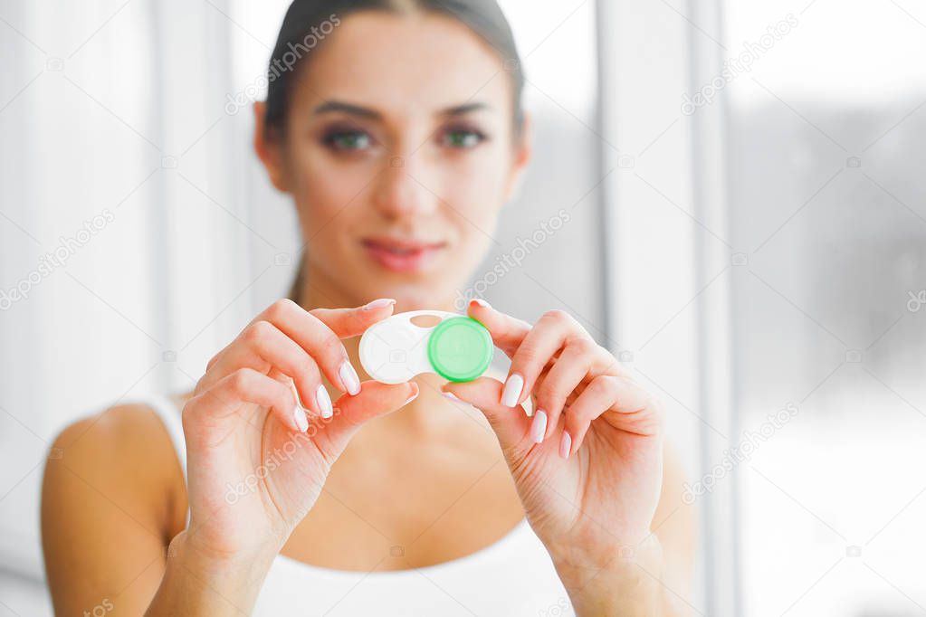 Vision And Medicine Concept. Young Girl Holds Eye Drops In Hands. Portrait of a Beautiful Woman with Contact Lenses. Healthy Look. High Resolution.