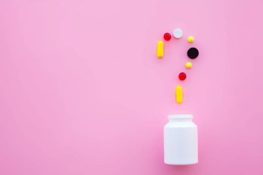 Tıbbi kavramı. Renkli hap ve kapsül pembe bir arka plan üzerinde. Eczane tema, kapsül hap ilaç antibiyotik paketleri ile.