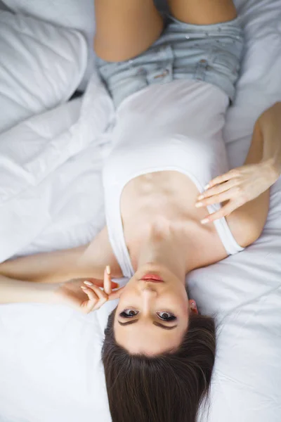 Retrato Uma Jovem Morena Sorridente Relaxando Cama Branca — Fotografia de Stock