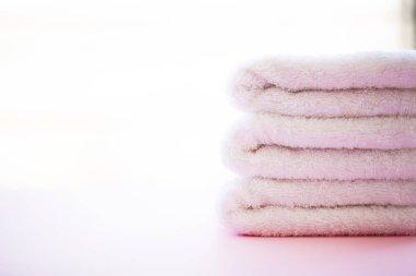 Spa. Beyaz Pamuk Spa banyo pembe bir arka plan üzerinde kullanımda havlu. Havlu kavramı. Otel ve masaj salonları için fotoğraf. Saflık ve yumuşaklık. Havlu Tekstil.