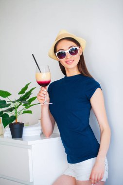 Tatil. Geri kalanı için hazırlanıyor olan kadın. Genç güzel kız yatak ve tutan eller kokteyl içinde oturur. Gülümseyen bir kadın portresi. Mutlu kız tatile gider.