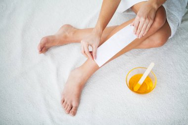Waxing. Depilation legs with waxing and tape. clipart