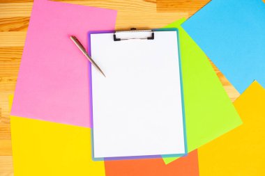 Bir klasörü bir mavi renk kağıt ve kalem ahşap masa renkli arka plan üzerinde tutan office el. Boşaltmak.