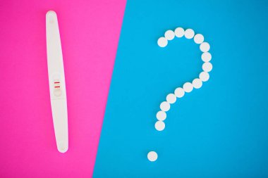 Gebelik planlama concep. Hamilelik testi pozitif iki çizgili ve mavi arka plan üzerinde Doğum kontrol hapı ile.