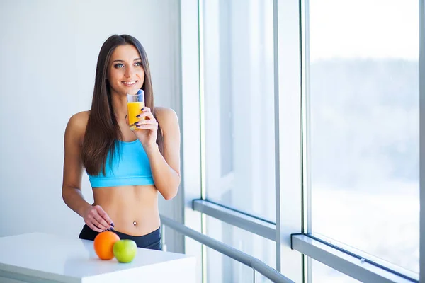 Diet. Young attractive happy woman with glass of juice.