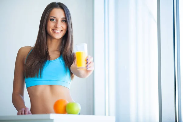Diet. Young attractive happy woman with glass of juice.