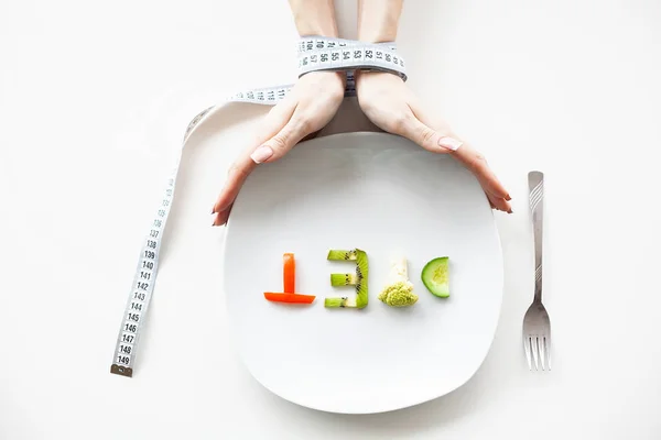 Diet or weight control concept. Centimeter tape and fork on a white background with a place for inserting text. concept of health, weight loss, diet, proper nutrition.