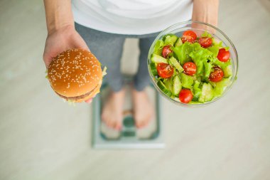 Diyet kavramı, güzel genç kadın sağlıklı gıda ve abur cubur arasında seçim yapma