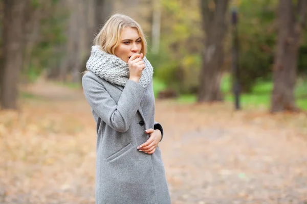 Girl sneezing in tissue. Young woman blowing her nose on the park. Woman portrait outdoor sneezing because cold and flu — Stock Photo, Image