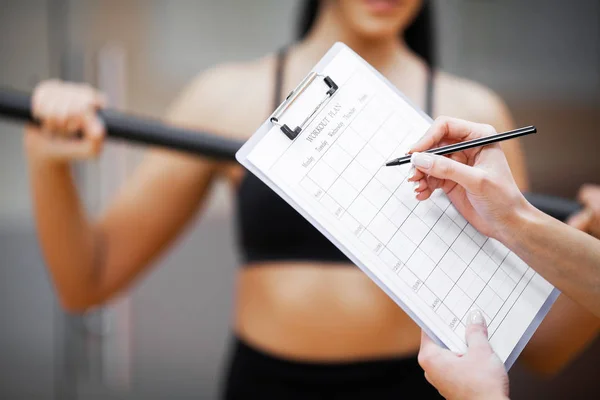 Fitness plan. Sports trainer amounts to workout plan close-up — Stock Photo, Image