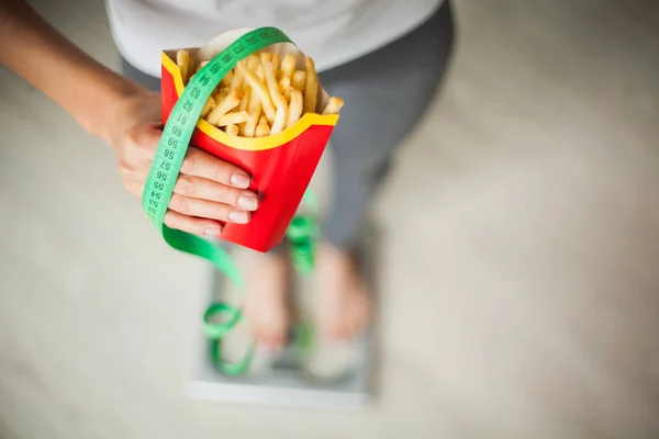 Bantning koncept, vacker ung kvinna att välja mellan hälsosam mat och skräpmat — Stockfoto