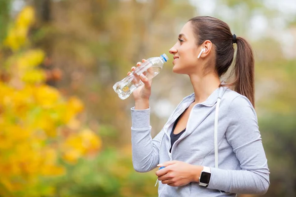 Бегун пьет воду. Фитнес, спорт и здоровый образ жизни — стоковое фото