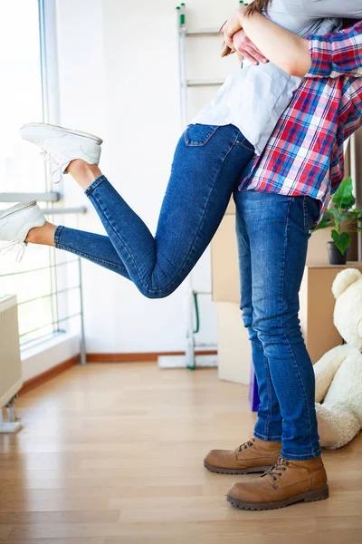 Neue Heimat. Lustiges junges Paar genießt und feiert den Umzug in ein neues Zuhause. Glückliches Paar in leerem Zimmer der neuen Heimat — Stockfoto