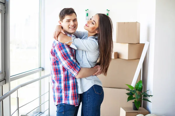 Nya hem. Roliga unga par njuta och fira flytta till nya hem. Lyckliga paret på tomt rum i nya hem — Stockfoto