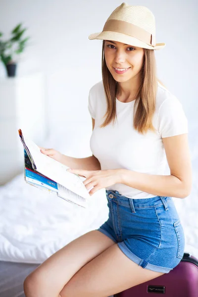 Vacation. Woman Who is Preparing for Rest. Young Beautiful Girl Sits on the Bed. Portrait of a Smiling Woman. Happy Girl Goes On Vacation — Stock Photo, Image