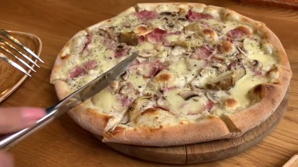 Cortando pizza. Mujer comiendo pizza en el restaurante . — Vídeos de Stock