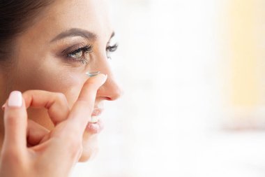 Sağlık. Genç kız tutar Kontakt Lens elinde. Yeşil gözleri ve kontakt lensler ile güzel bir kadın portresi. Sağlıklı bir görünüm. Yüksek çözünürlük