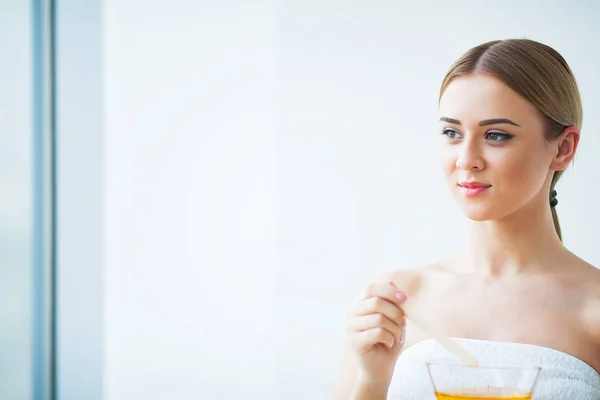 Vrouwen houden oranje paraffine kom. Vrouw in de beauty salon — Stockfoto
