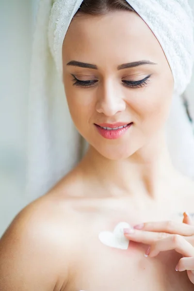 Een mooie vrouw met behulp van een product van de huidzorg, vochtinbrengende crème of lotion en huidverzorging het verzorgen van haar droge teint. Hydraterende crème in vrouwelijke handen — Stockfoto