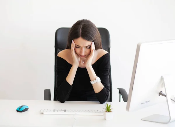 Mal à la tête. Jeune femme épuisée ressentant une douleur à la tête après avoir travaillé sur ordinateur. Concept de surcharge de travail — Photo