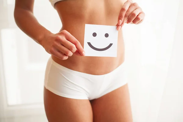 Salud de las mujeres. Hermoso cuerpo femenino en bragas con tarjeta de sonrisa — Foto de Stock