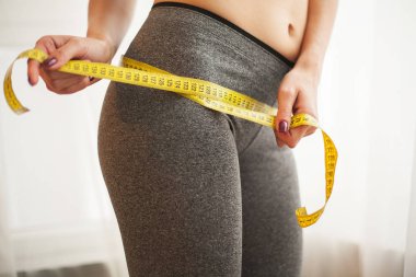Eller bel bandı ile ölçme. İnce ve sağlıklı kadın evinde