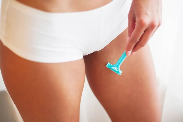 Primo piano di giovane ragazza che si depila la gamba in bagno — Foto Stock