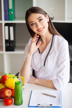 Diyet ve sağlıklı bir kavram. Ofisinde gülümseyen beslenme uzmanı