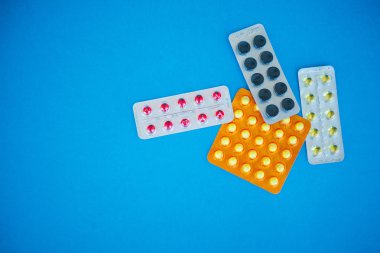 Tıbbi ilaçlar. Renkli hap ve kapsül mavi zemin üzerine. Eczane tema, kapsül hap ilaç antibiyotik paketleri ile