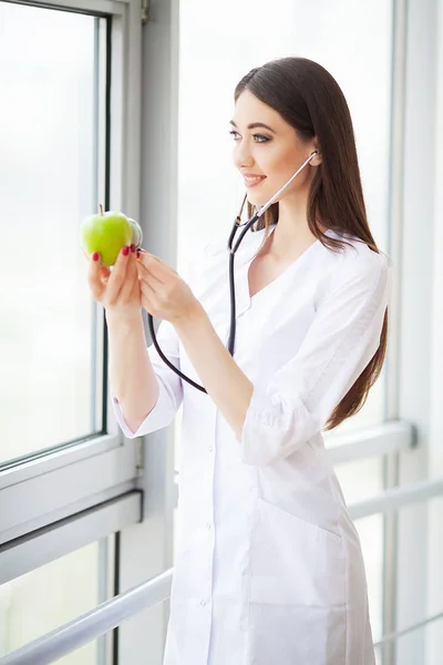 Δίαιτα. Ευτυχισμένος ιατρός γυναίκα δείχνει apple και στηθοσκόπιο — Φωτογραφία Αρχείου