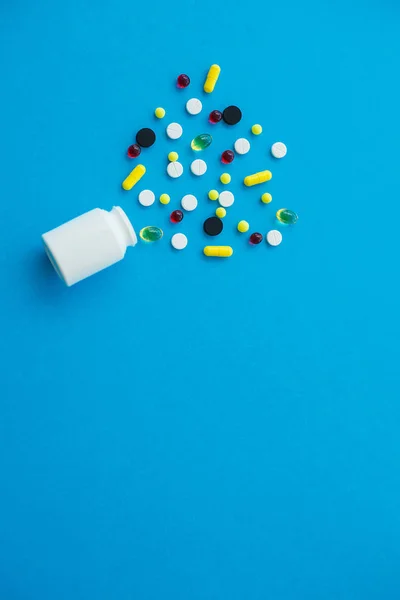Pillole mediche. Pillole colorate e capsula su sfondo blu. Tema della farmacia, pillole della capsula con antibiotico della medicina nei pacchetti — Foto Stock