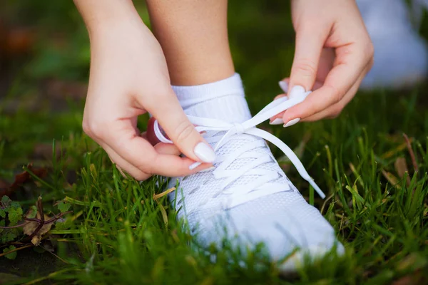 Healthy lifestyle. Beautiful woman runner tying shoelaces Stock Image
