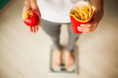 Diyet. Kadın vücut ağırlığı sağlıksız abur cubur tutan ölçek ağırlığında üzerinde ölçüm. Kilo kaybı. Obezite. Üstten görünüm