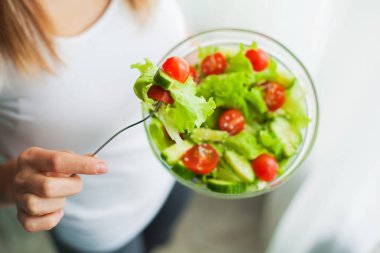 Diyet ve sağlıklı beslenme. Genç kadın sağlıklı salata egzersiz sonrası yemek