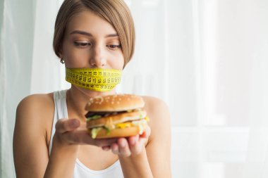 Diyet kavramı ve sağlık. Ölçme bantları ağız ve sağlıksız foodat onu eve ile duygusal kadın