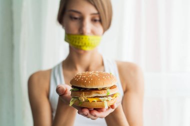 Diyet kavramı ve sağlık. Ölçme bantları ağız ve sağlıksız foodat onu eve ile duygusal kadın