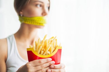 Diyet kavramı ve sağlık. Ölçme bantları ağız ve sağlıksız foodat onu eve ile duygusal kadın