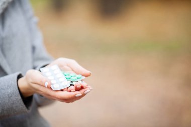 Soğuk algınlığı ve grip. Sonbahar park holding hapları kadında