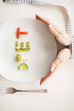 Beslenme veya kilo kontrolü kavramı. Santimetre teyp ve metin eklemek için bir yer ile beyaz bir arka plan üzerinde çatalı. Sağlık, kilo kaybı, diyet, doğru beslenme kavramı