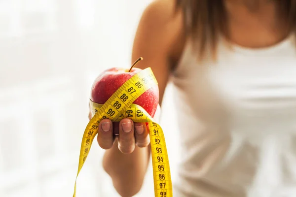 Diet and Health. Red apple and centimeter tape in female hands — Stock Photo, Image